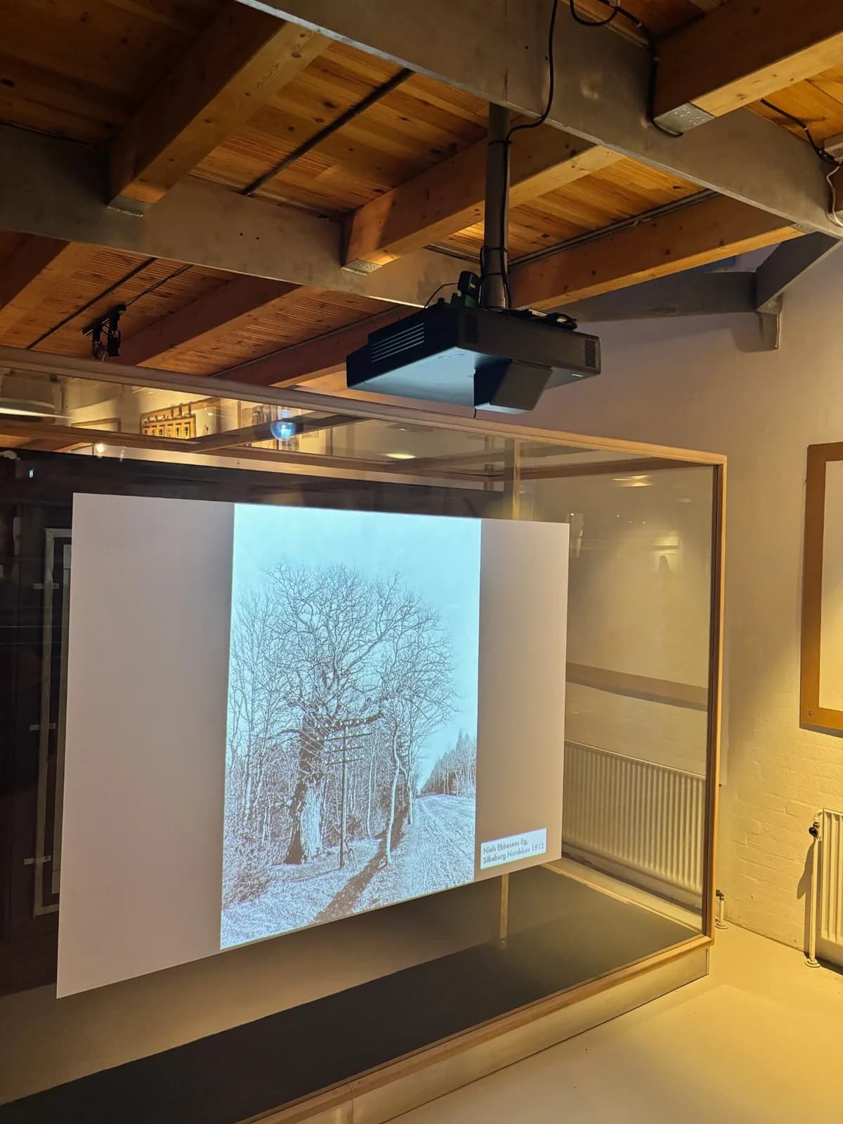 Loftmonteret projektor over et projiceret historisk billede i en glasramme